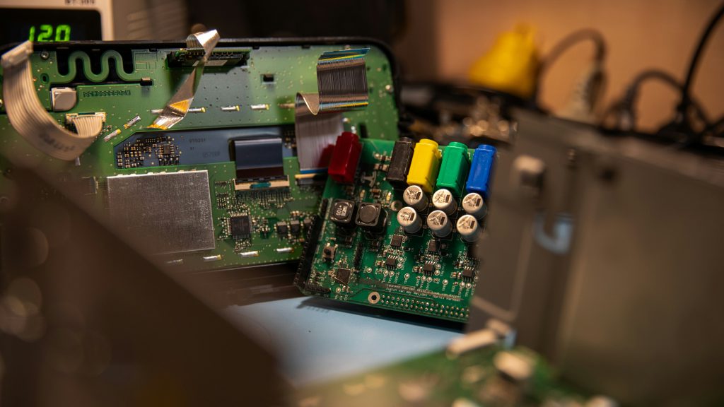 Na zdjęciu widać wnętrze urządzenia elektronicznego z odsłoniętą płytą główną