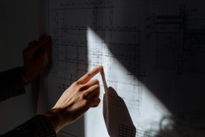 modelowanie 3D w budownictwie - ręka człowieka z planami budowy